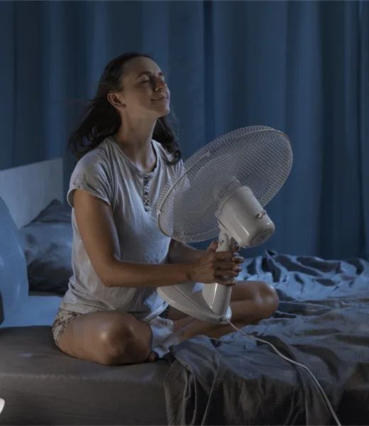 Woman enjoying fresh air from a fan